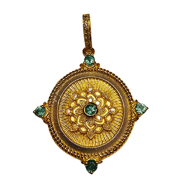 a gold medallion with green gems