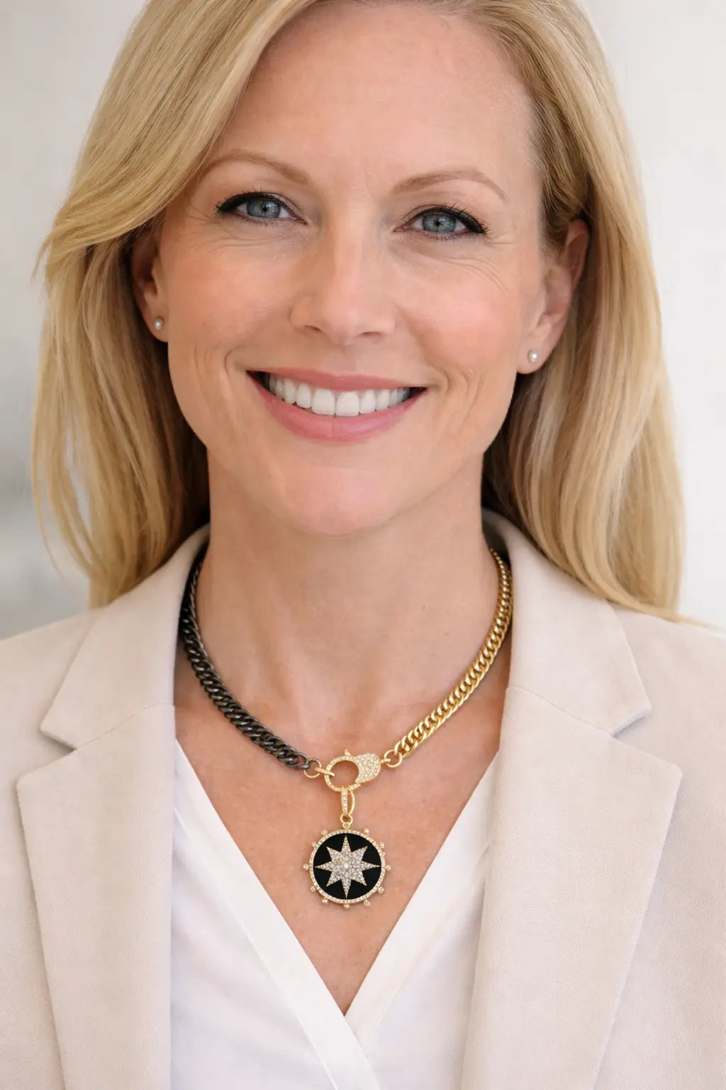Woman wearing a gold and black cuban necklace with a black onyx pendant against a white background