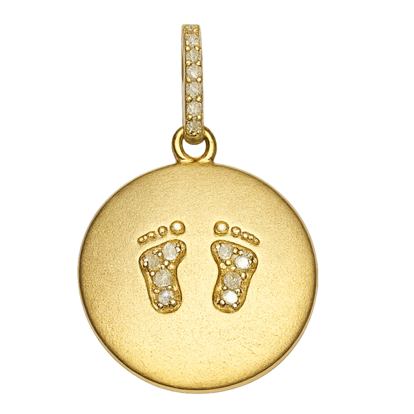 a gold pendant with a foot print